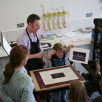 A teacher showing the class a students print